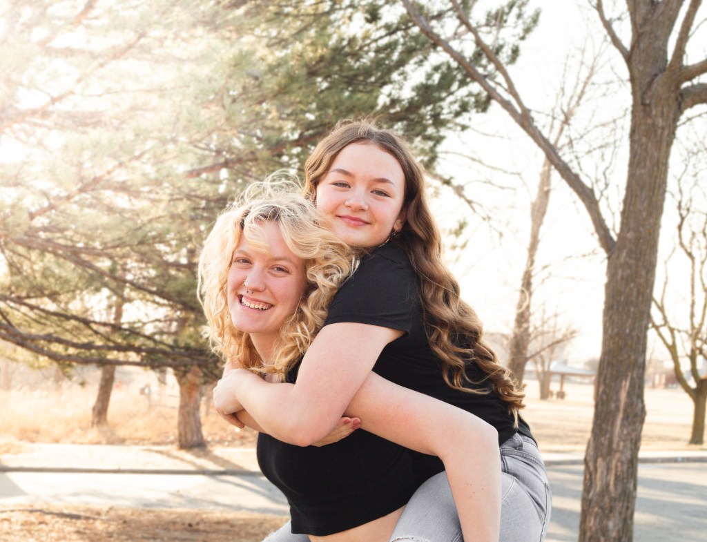Sisters doing a piggy back right during photography session