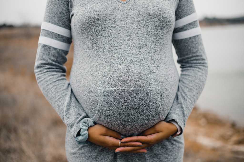 Mom with hands under baby bump