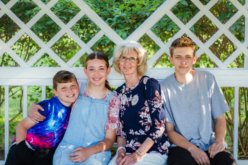 Grandma and grandkids smiling under gazebo