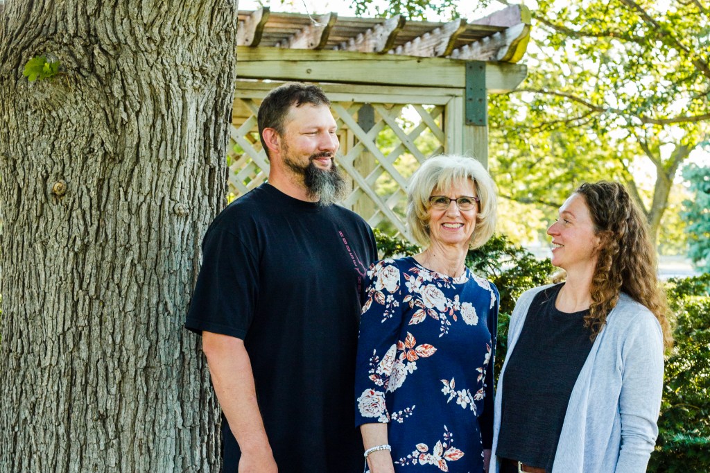 Adult kids smiling at their mother being photographed by Sam Highsmith Photography